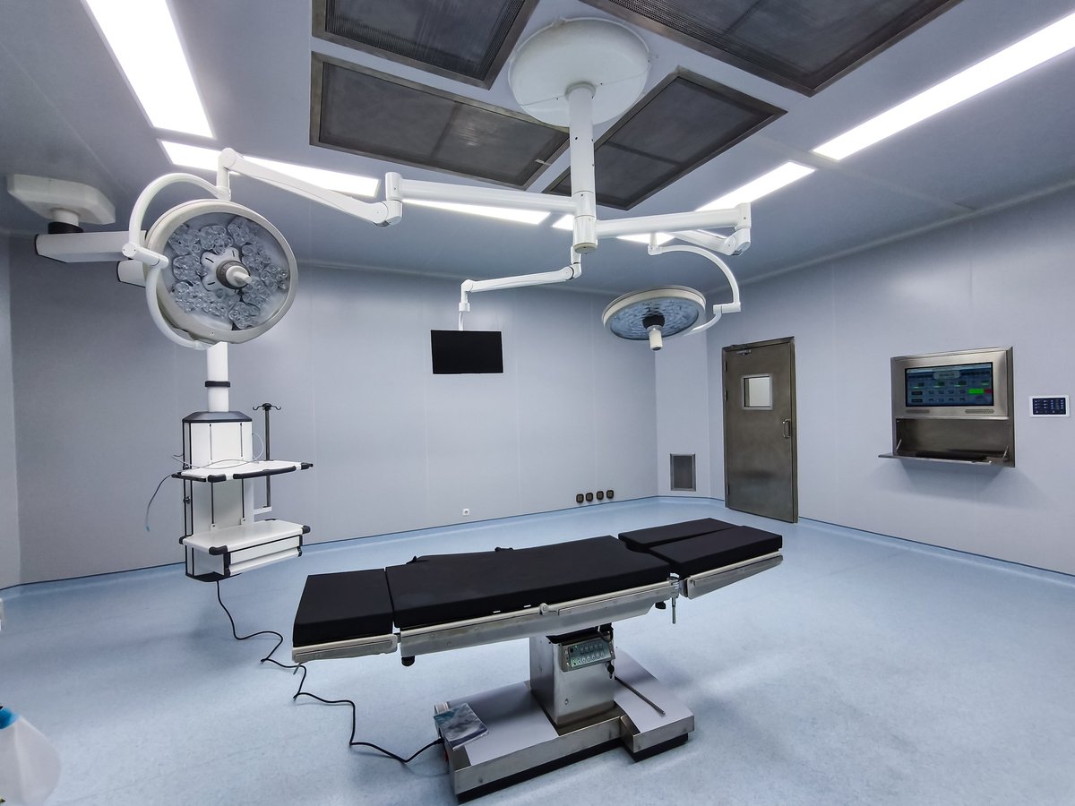 Medical operating bed in a modern hospital operating room with surgical lights and sterile equipment